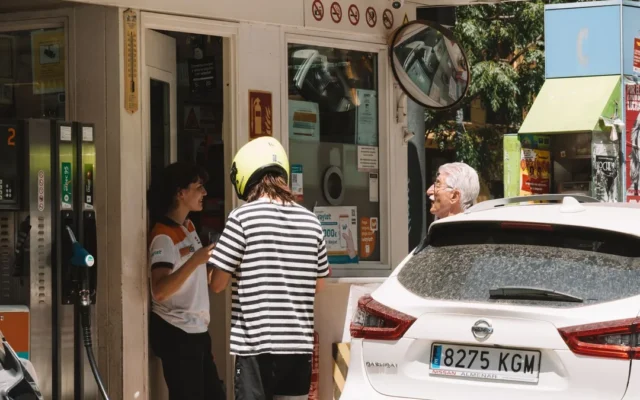 Persoane și autoturisme la o stație de alimentare