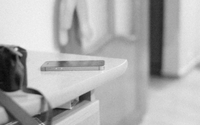 Telefon mobil pe o masă, într-o fotografie alb-negru