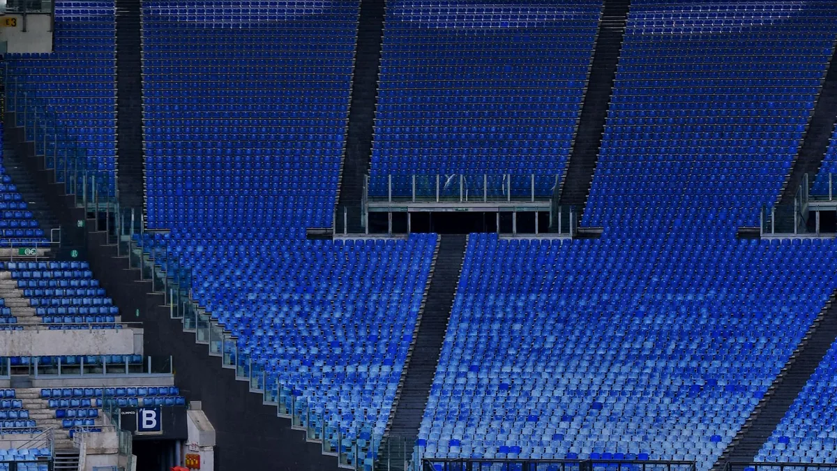 Tribune goale cu scaune albastre într-un stadion de fotbal
