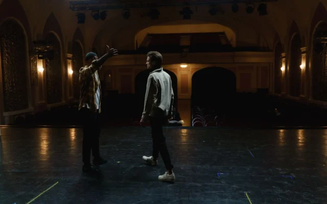 Doi actori pe scena unui teatru în timpul unei repetiții