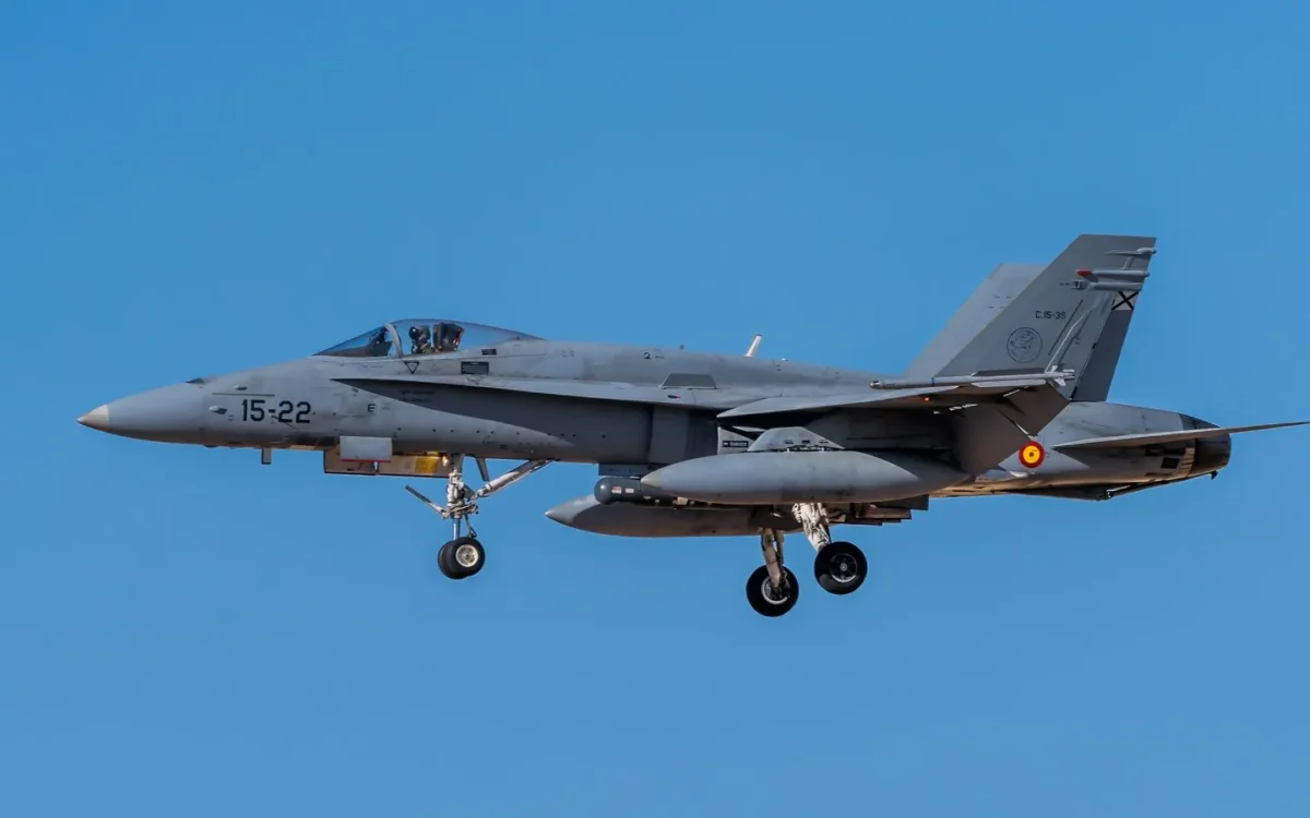 Avion F-18 cu însemne spaniole în zbor, cu trenul de aterizare coborât