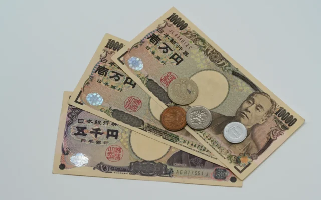 Bancnote și monede în yeni japonezi așezate pe o suprafață