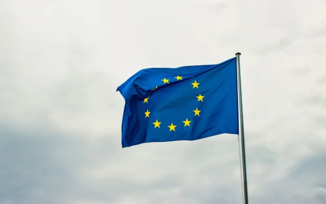 Drapelul Uniunii Europene fluturând pe un cer cu nori