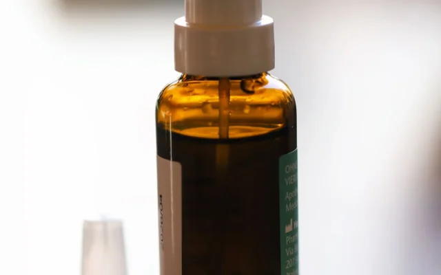 Flacon cu pulverizator nazal și un blister cu capsule pe masă