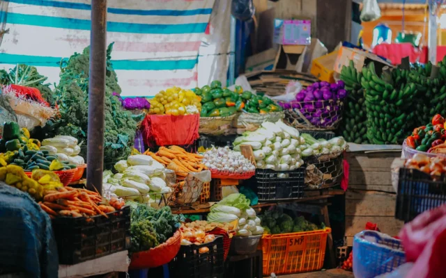 Fructe și legume în lăzi și coșuri la o tarabă de piață