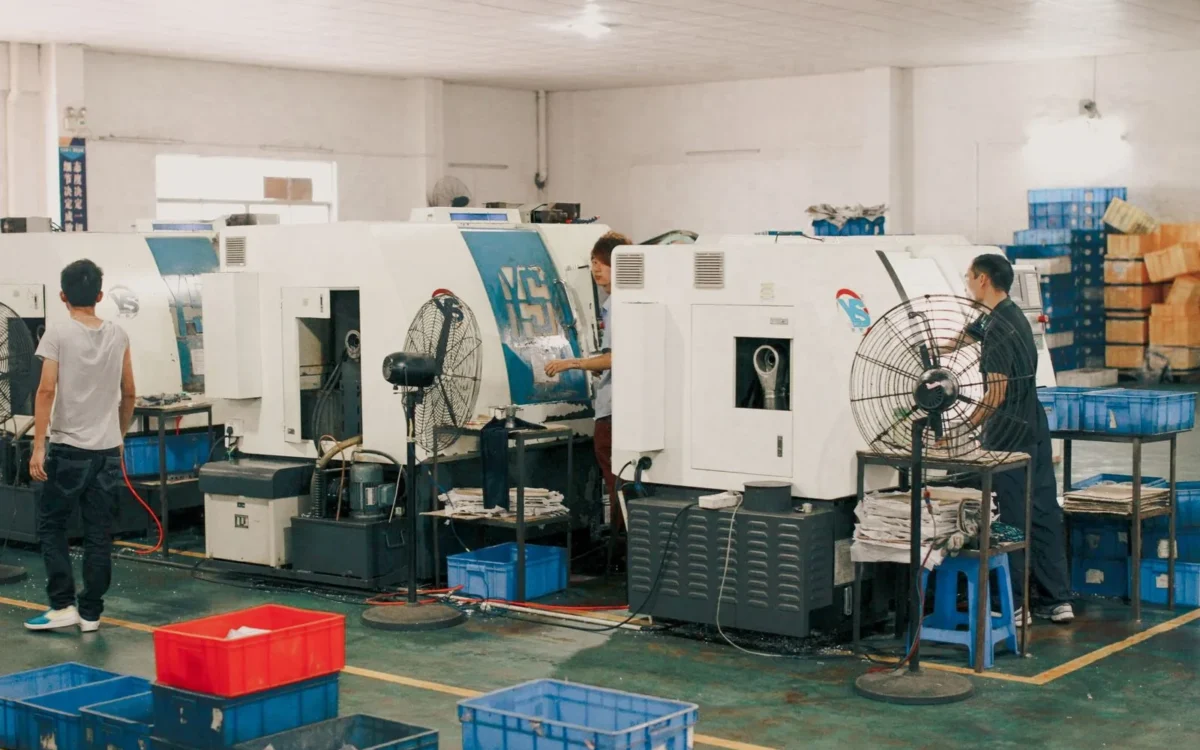 Lucrători lângă utilaje într-o hală industrială