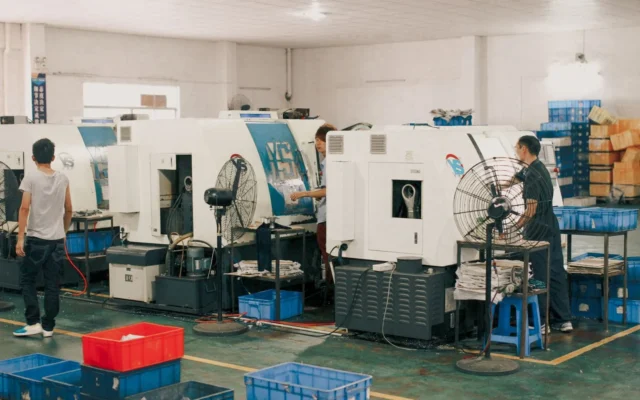 Lucrători lângă utilaje într-o hală industrială