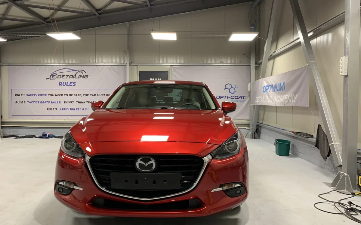 Un automobil Mazda roșu, fotografiat din față în atelierul EDetailing.