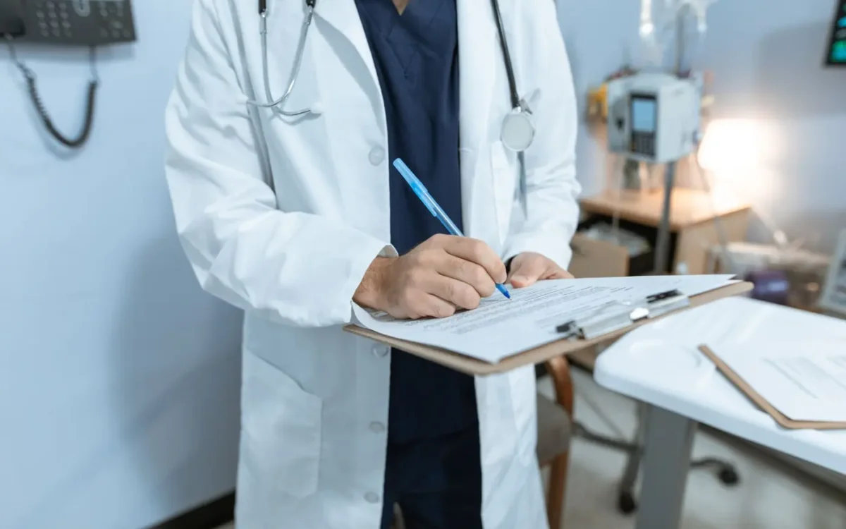 Medic completând un formular pe o planșetă