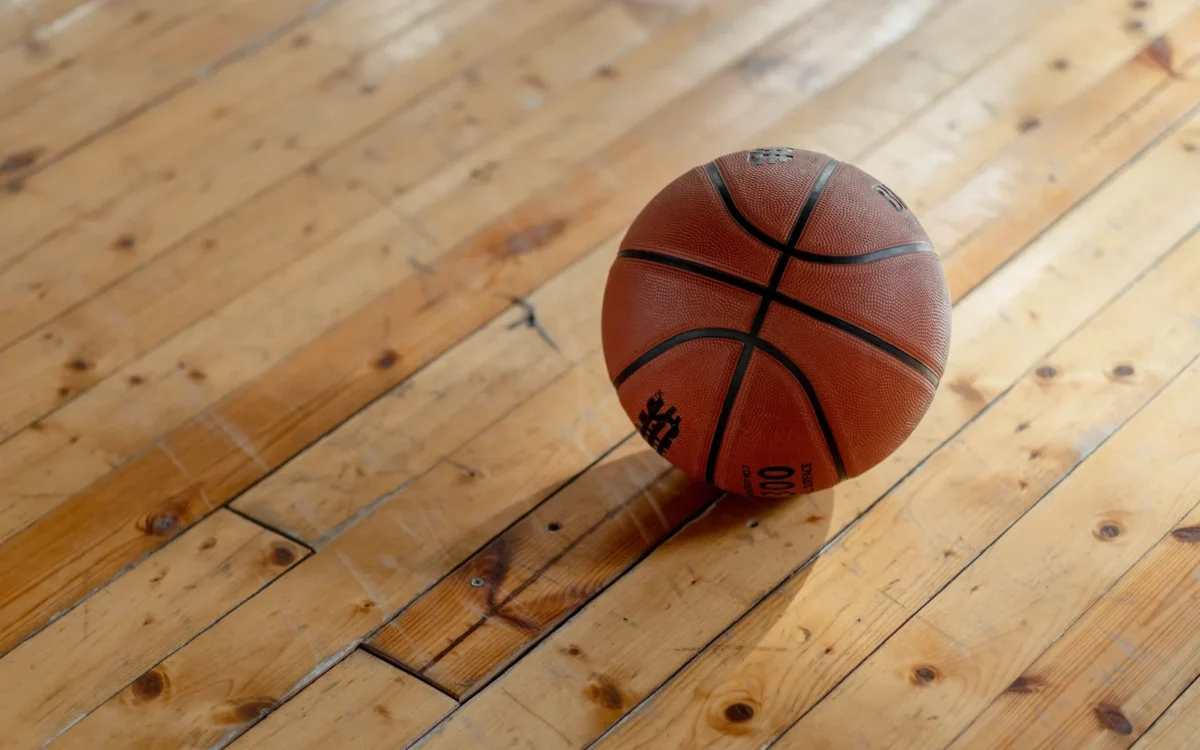 Minge de baschet pe parchetul unei săli de sport