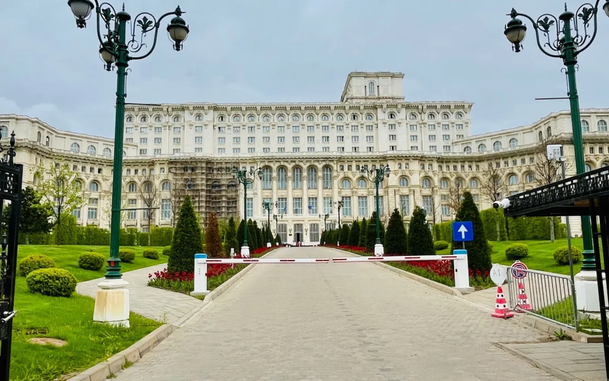 Fațada și intrarea Palatului Parlamentului din București, între felinare