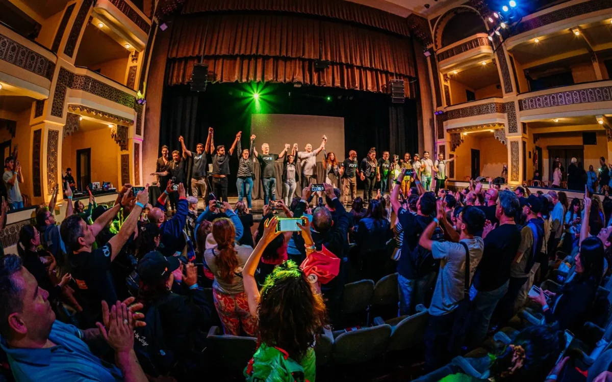 Publicul aplaudă artiștii pe scena unui teatru