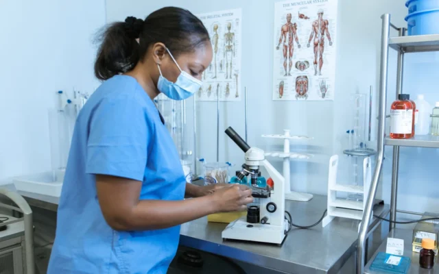 Specialist de laborator folosește un microscop
